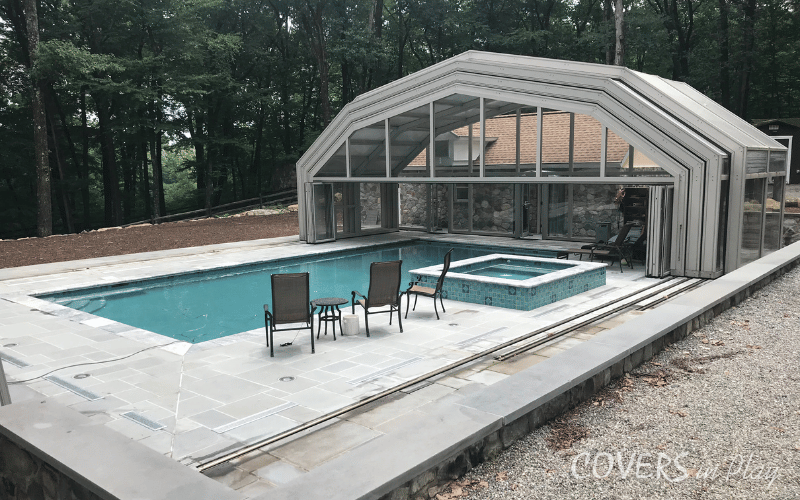Alternate side view of fully opened pool dome in backyard of home in Kinnelon