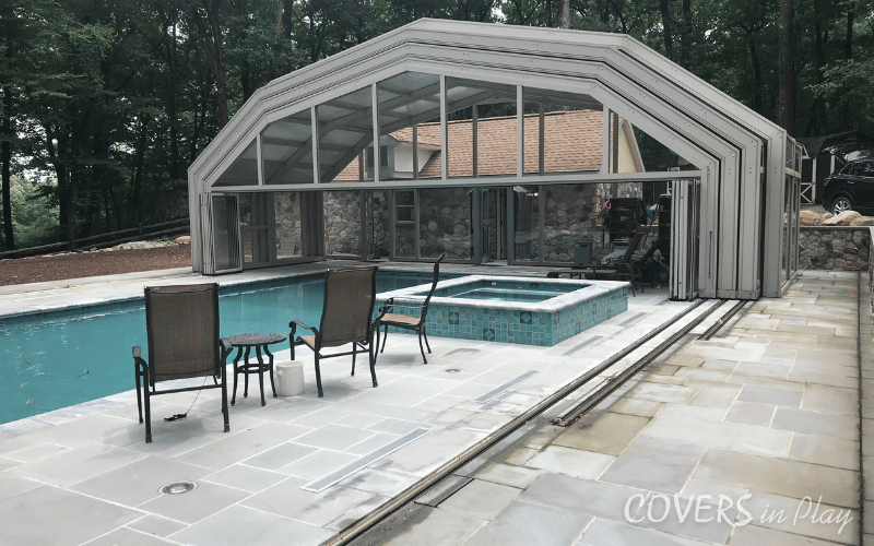 Side view of fully opened pool dome with a pool and hot tub in Kinnelon
