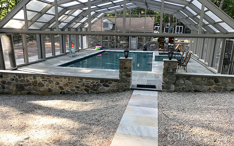 Front exterior view of closed residential pool enclosure with opened bifold doors in Kinnelon backyard
