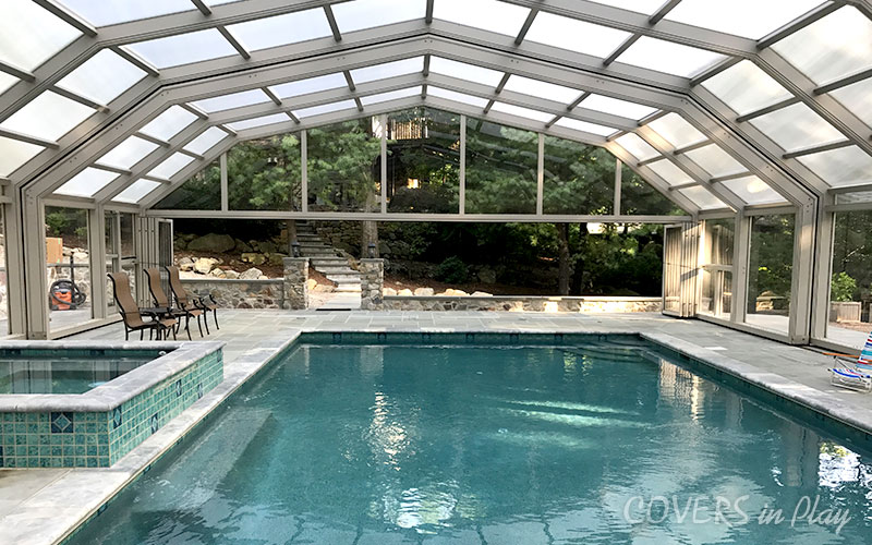 Front interior view of closed residential pool enclosure with opened bifold doors in Kinnelon