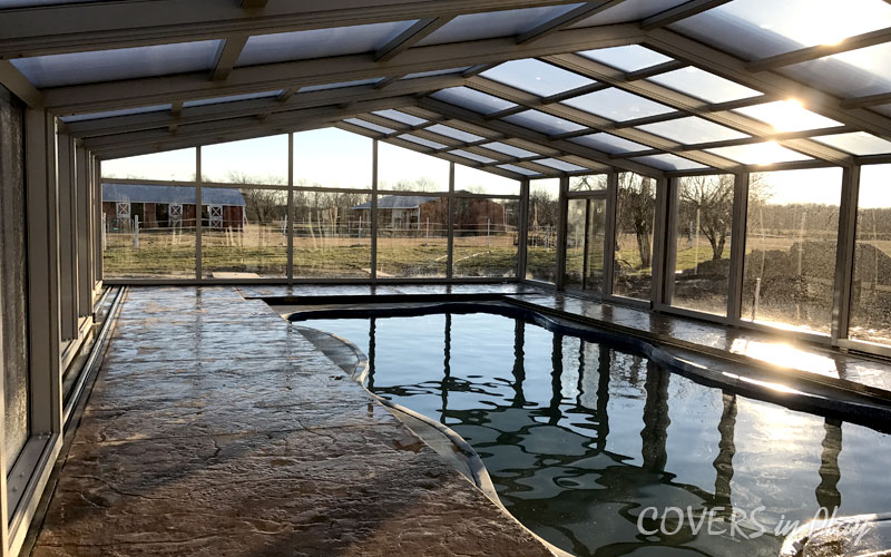 Inside view of a closed pool enclosure with clear windows in Clayton