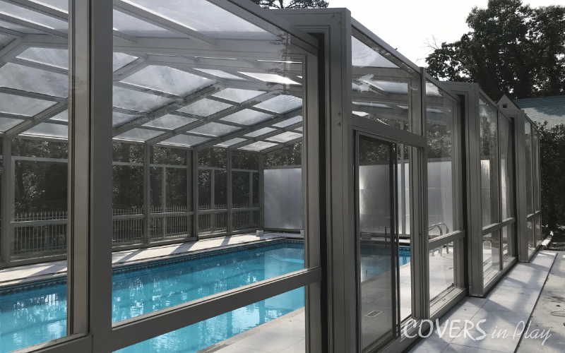 Alternate side exterior view of closed residential pool dome in Lakewood backyard with sliding doors