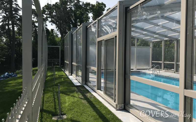 Side exterior view of closed residential pool dome in Lakewood backyard