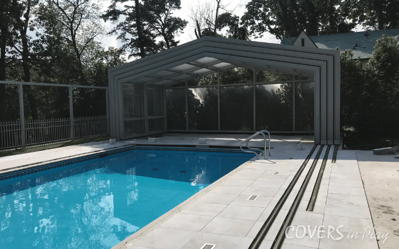 Angled side exterior view of opened residential retractable pool enclosure in Lakewood backyard