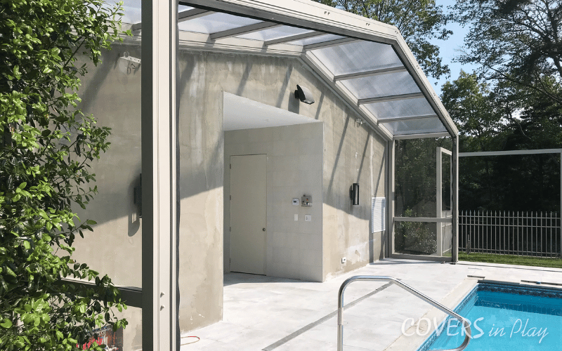 Side view of fixed bay of opened retractable pool enclosure in Lakewood