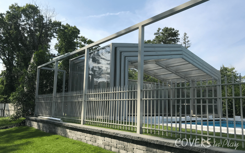 An exterior side view of an opened retractable pool enclosure in Lakewood