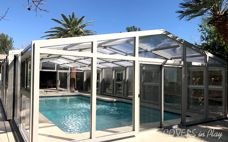 Rear angled exterior view of closed pool cover dome with sliding door in Mesa residential home