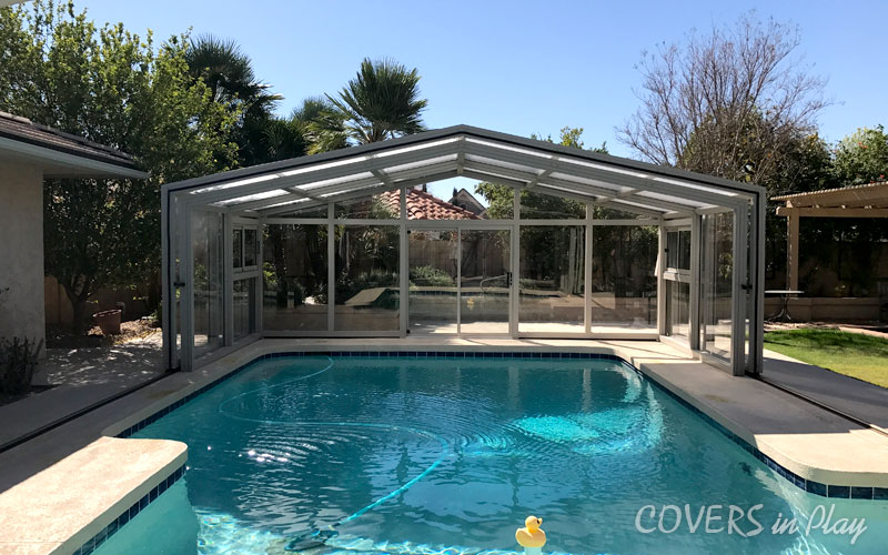 Front interior view of opened pool dome surrounded by lush greenery in Mesa