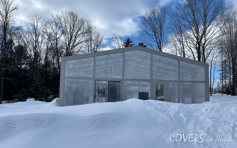Rear exterior view of pool enclosure in Minden, with snow piling against the structure