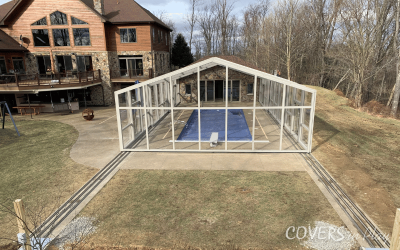 Rear view of large residential backyard pool enclosure in Triadelphia, WV