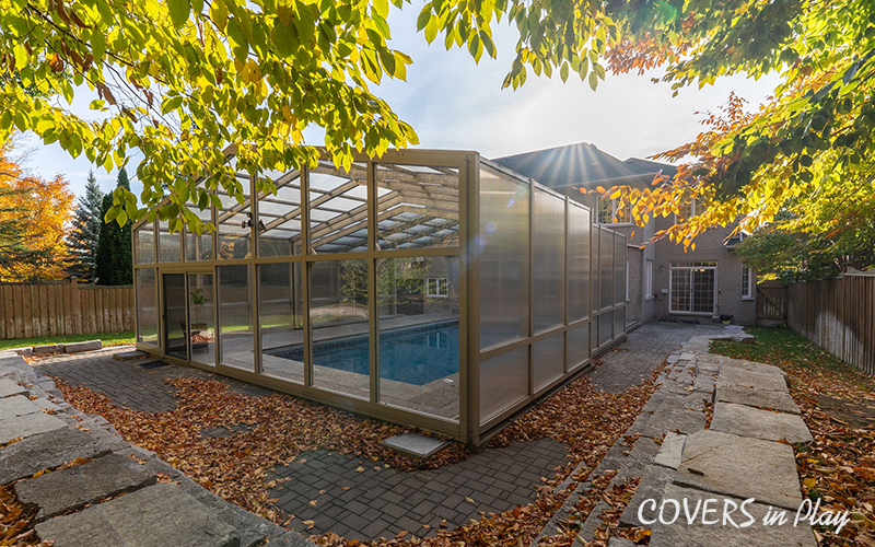 Rear angled view of closed pool enclosure attached to a house in Whitby in the fall