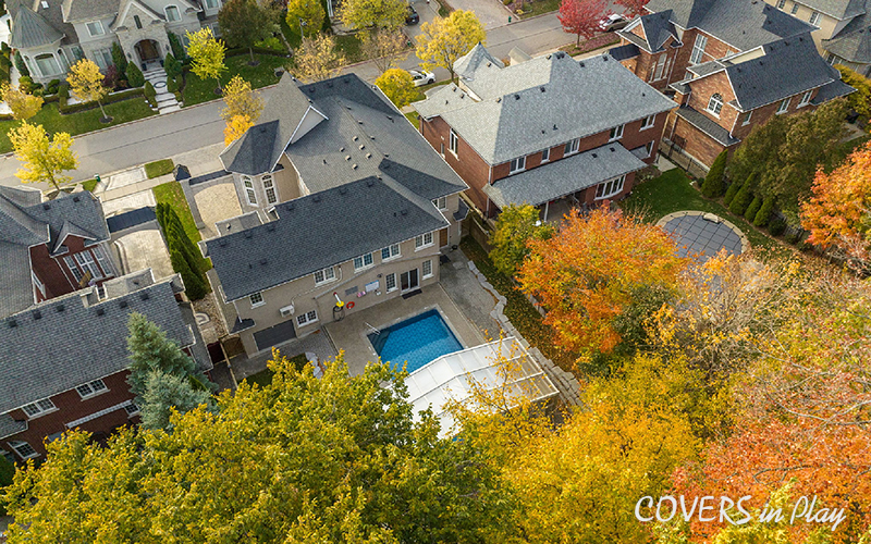 Top angled view of opened pool enclosure and house in suburban neighbourhood in Whitby