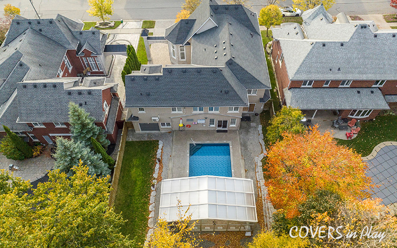 Top angled view of opened pool enclosure and house in suburban neighbourhood in Whitby