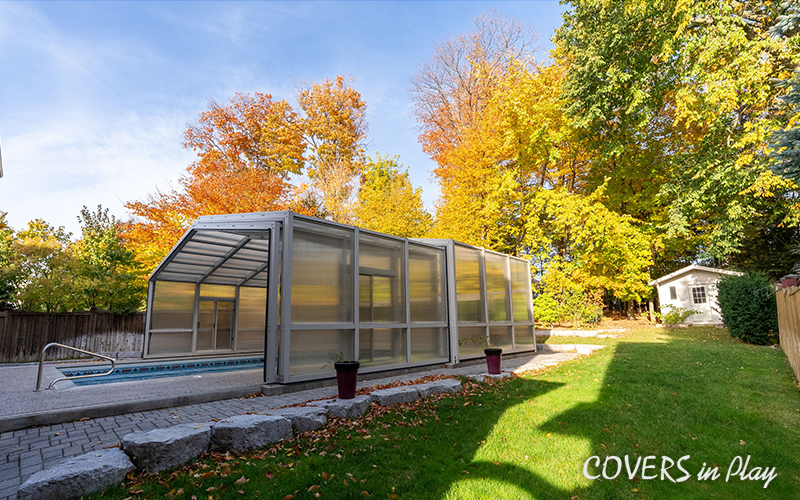 Side view of opened pool enclosure with frosted windows in Whitby surrounded by trees