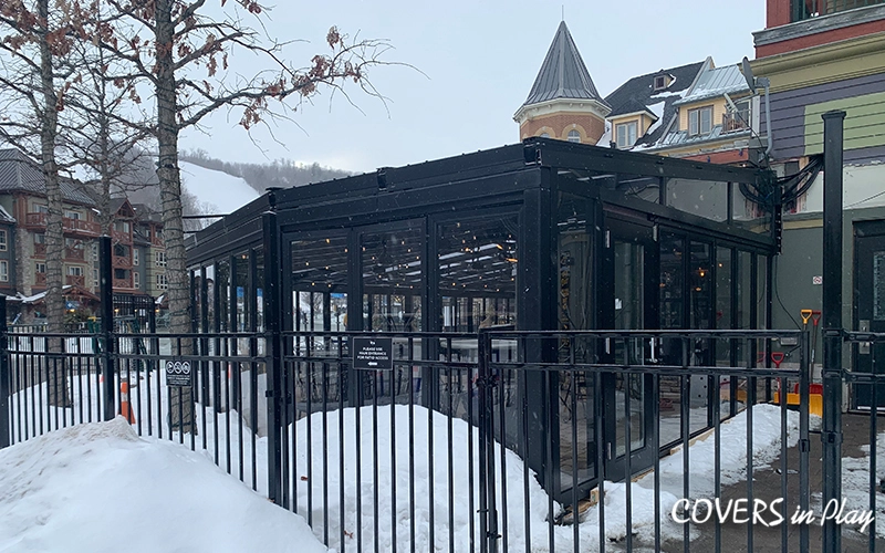 Rear view of patio enclosure at Blue Mountain restaurant, with snowy ground and mountains in the background