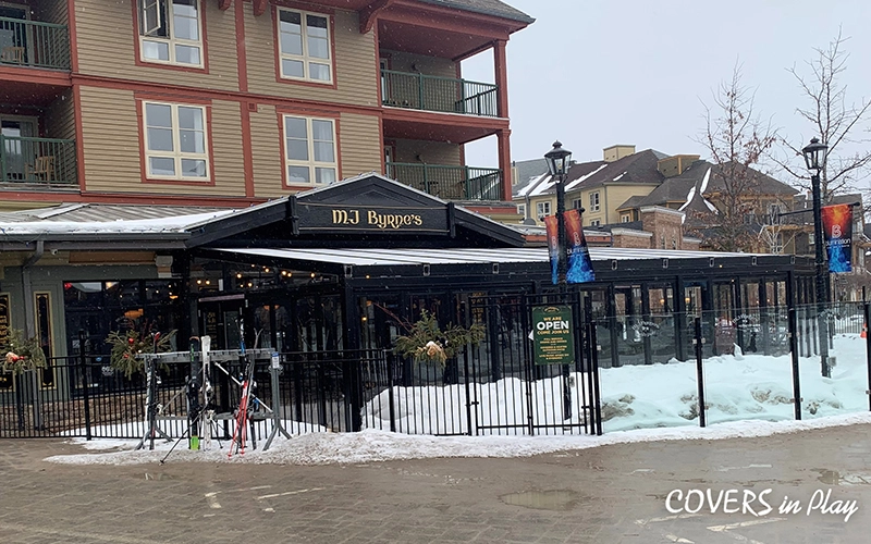 Wide view of Blue Mountain restaurant with patio enclosure, closed bi-fold doors, and snow on the ground