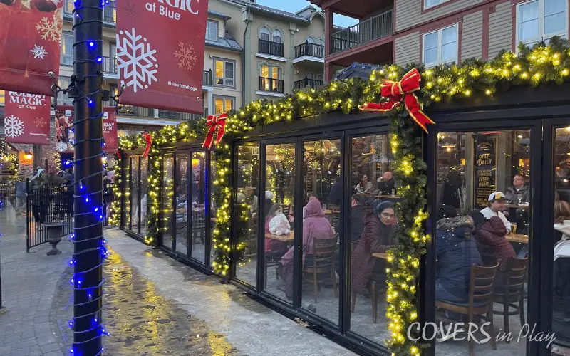 Side view of commercial Blue Mountain patio enclosure with bi-fold doors and festive Christmas lights