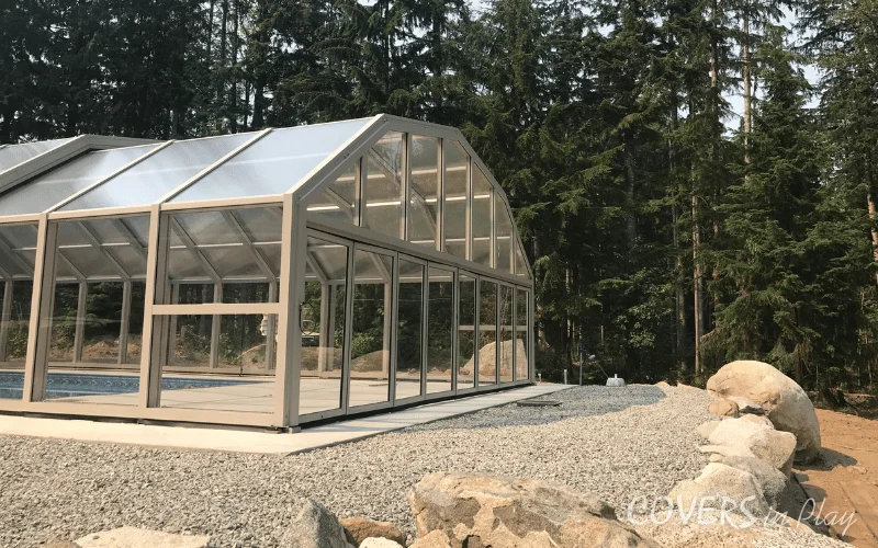Side rear view of closed pool enclosure in BC, showing the integration into its environment