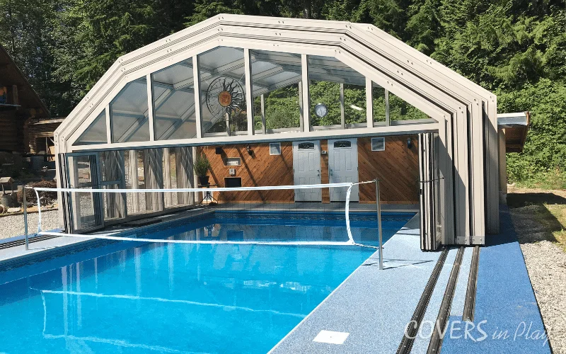 Side view of open pool enclosure in BC, showing the enclosure tracks seamlessly integrated into the pool deck floor