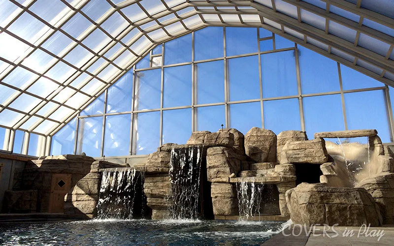 Wide view of residential backyard pool dome and waterfall in Nephi, UT
